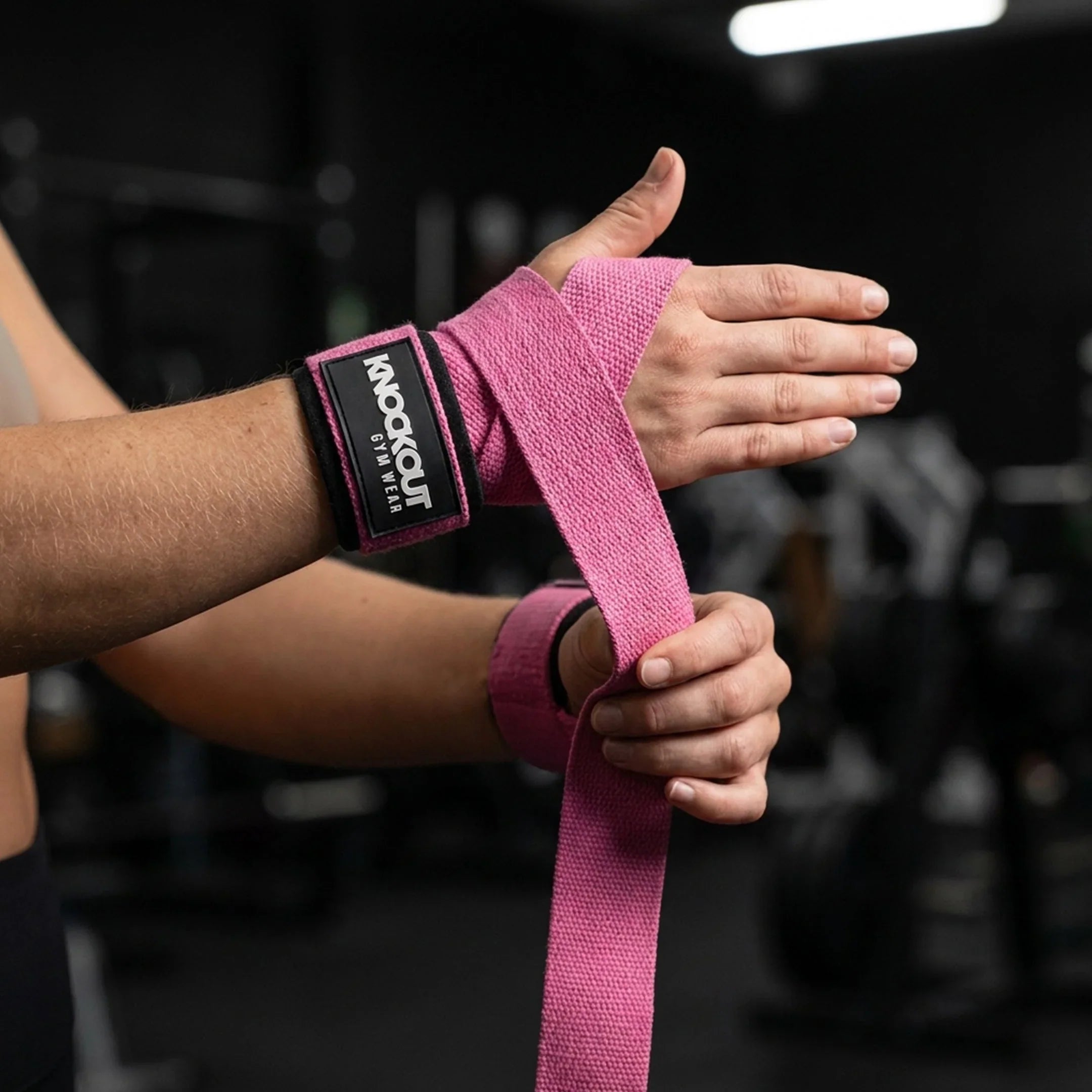 Pink weightlifting lifting straps wrapped around wrists for strength training by Knockout Gymwear USA